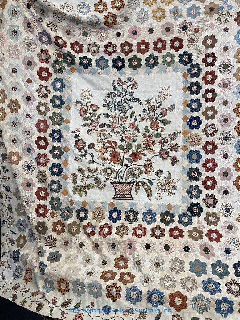 Antique quilt from Janet O'Dell's collection featuring a broderie perse centre and outer border framed by hexagons
